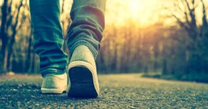 Beine auf einem Waldweg im Sonnenaufgang